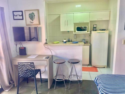 里贝朗普雷托RAVENA 11的厨房配有2张凳子和带冰箱的台面