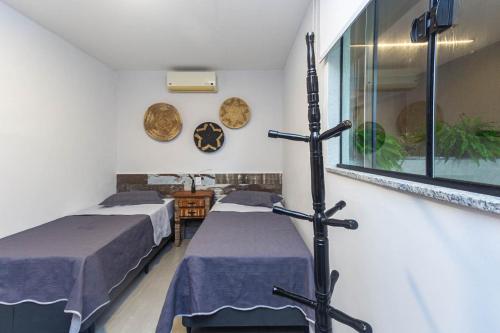 ItaipuPê na areia Loft Praia de Itaipú的一间医院间,设有两张床和窗户