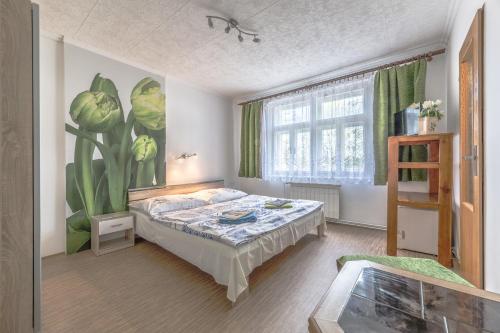 尼萨河畔亚布洛内茨波科尔尼旅馆的卧室配有一张床,墙上挂有绘画作品