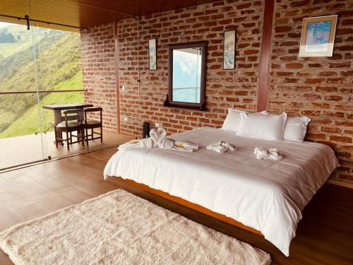巴尼奥斯Casa de Campo El Descanso的一间卧室设有一张大床和砖墙
