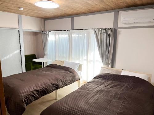 出云市Izumo no Oyado Naka Araki - Vacation STAY 82773v的一间卧室设有两张床和窗户。