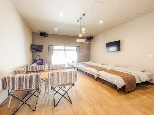 广岛Riverside Glamping Kamiseno - Vacation STAY 92757v的一间设有四张床和一张桌子及椅子的房间