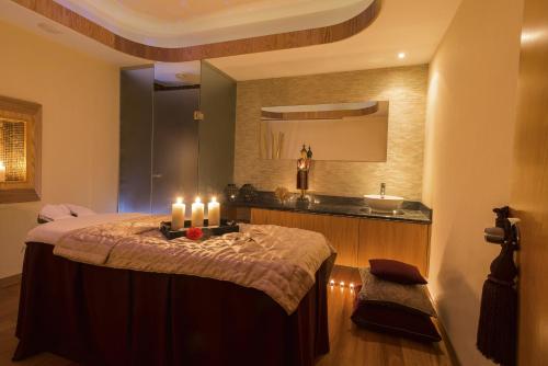 帕福斯康斯坦丁诺雅典娜海滩酒店的浴室设有一张带蜡烛的床。