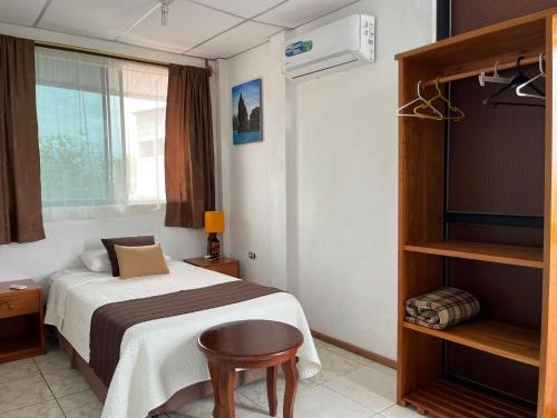 阿约拉港Maytenus Galapagos的卧室配有床、椅子和窗户。