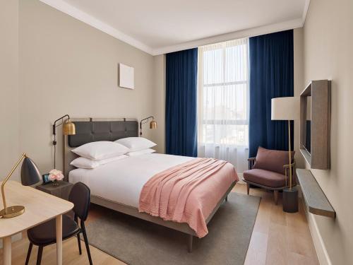 纽约11 Howard, New York, a Member of Design Hotels的一间卧室配有一张床、一张桌子和一把椅子