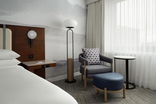 长滩Marriott Long Beach Downtown的配有一张床和一把椅子的酒店客房