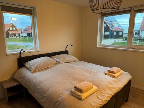ScherpenisseAttractive holiday home in Scherpenisse with roofed terrace的一间卧室配有一张床,上面有两条毛巾