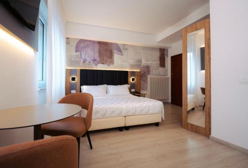 特伦托珠峰酒店的酒店客房带一张床、一张桌子和椅子
