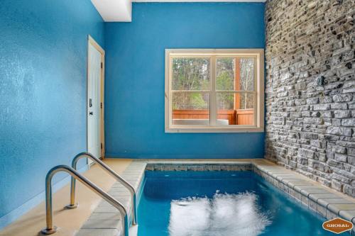 鸽子谷Rustic Mountain Retreat by Ghosal Luxury Lodging的蓝色客房的游泳池,设有窗户