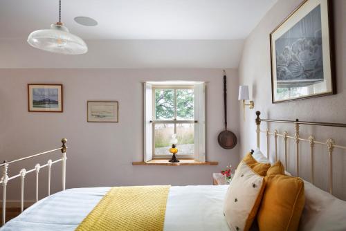 RashennySecluded Thatched Cottage, near beaches & hill walking的一间卧室设有一张床和一个窗口