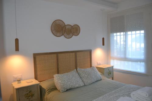 托雷加迪亚罗Beach and Golf House Sotogrande - Torreguadiaro的一间卧室配有带2个床头柜和2个窗户的床