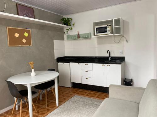 弗洛里亚诺波利斯Residencial Sullivan - Florianópolis - Loft 01的一间带桌子的客厅和一间厨房