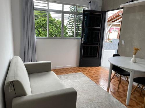 弗洛里亚诺波利斯Residencial Sullivan - Florianópolis - Loft 01的客厅配有椅子和桌子