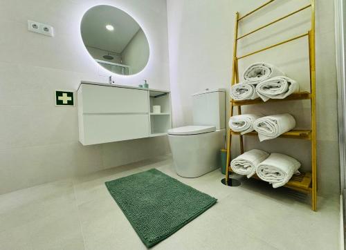 阿威罗Central Tiled Apartment的一间带卫生间、镜子和毛巾的浴室