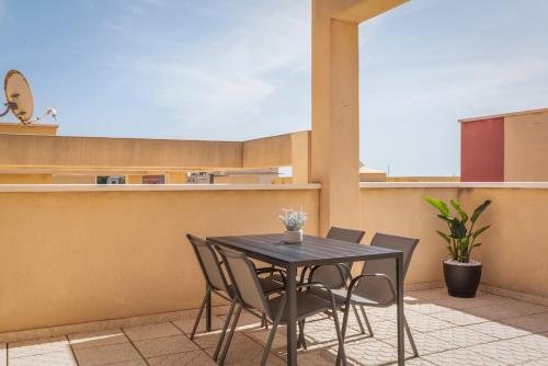 马萨龙港Apartamento Las Brisas, Atico的阳台上配有一张黑色的桌子和椅子