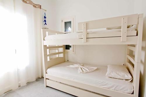 帕罗斯岛Dolce Vita Waterfront Villa, Logaras, Paros的卧室配有带白色墙壁的双层床