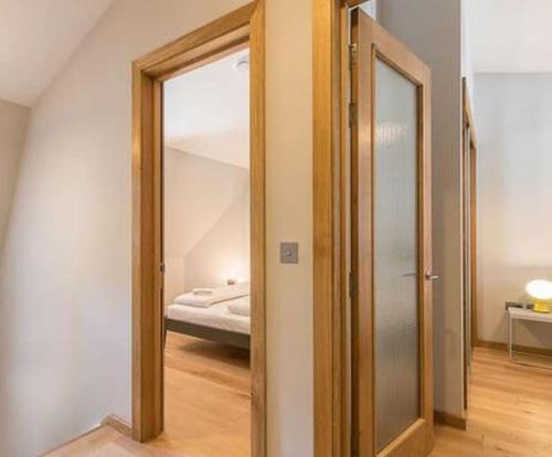 伦敦Holborn Home: Find Iconic London的走廊上设有镜子和一张位于客房内的床