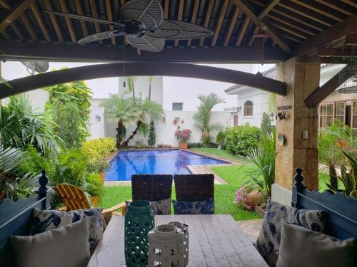 瓜亚基尔Casa en Samborondón的一个带游泳池和吊扇的庭院