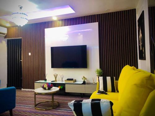 伊凯贾willy-richy Apartments的客厅配有黄色沙发和平面电视。