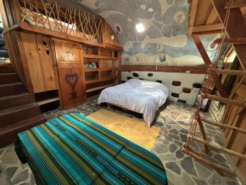 圣马科斯拉拉古纳Earthship 3 levels apartment starboard cabin with lake view的一间卧室,卧室内设有床和楼梯