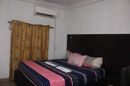 莱基D'Island hotel and club的一间卧室配有一张带黑色床头板和枕头的床。
