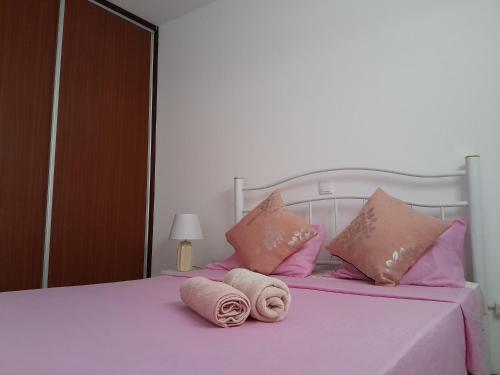 蓬塔杜索尔AP Hélder Bentub的一张带粉红色枕头的床和毛巾