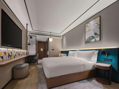 杭州杭州西湖希尔顿花园酒店的一间酒店客房,配有一张大床和一台平面电视