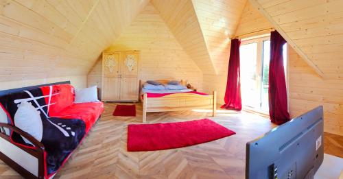 穆扎希赫尔ECO Domek z dużym ogrodem i widokiem的客厅配有红色的沙发和床。