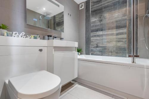 泰晤士河畔金斯顿Elegant Living in Kingston: Two Bedroom Apartment的白色的浴室设有卫生间和淋浴。