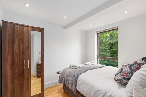 泰晤士河畔金斯顿Elegant Living in Kingston: Two Bedroom Apartment的一间卧室设有一张大床和一个窗户。