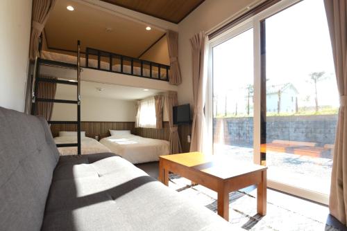 富士河口湖Mt Fuji Glamping VILLA Kawaguchiko的一间卧室配有双层床和沙发