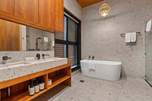 温特沃斯瀑布Sandbox House - Luxury Architectural Retreat的浴室配有白色浴缸和水槽