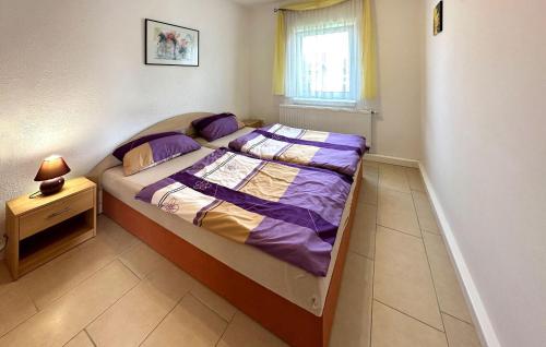 克林克1 Bedroom Stunning Home In Klink的一间小卧室,配有一张带紫色床单的床