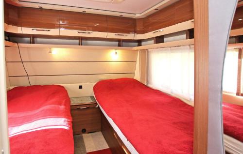 KagarAmazing stacaravan In Rheinsberg Ot Kagar With Kitchen的小客房内的两张床,配有红色床单