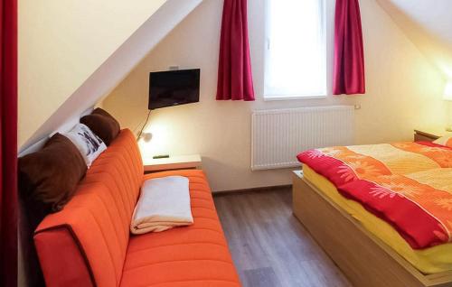 NeuhausCozy Apartment In Dierhagen ostseebad With Kitchen的一间卧室配有橙色的沙发和一张床