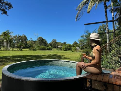 佩里吉安比奇努萨维巴湖屋舍酒店的坐在游泳池旁的比基尼的女人