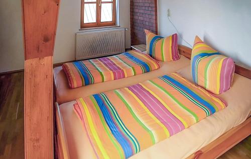 KölpinBeautiful Home In Klpin With Kitchen的一张大床,配有色彩缤纷的床单和枕头