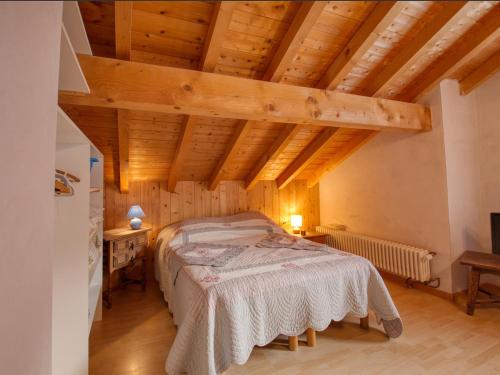 萨莫安斯Chalet Samoëns, 5 pièces, 10 personnes - FR-1-642-3的一间带一张床的卧室,位于带木制天花板的房间内