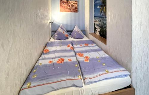 StubbenfeldeCozy Apartment In Klpinsee-usedom With Wifi的一张床上铺有紫色床单和橙色鲜花