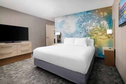 康科德康科德万豪万怡酒店的一间卧室配有一张大床和一台平面电视