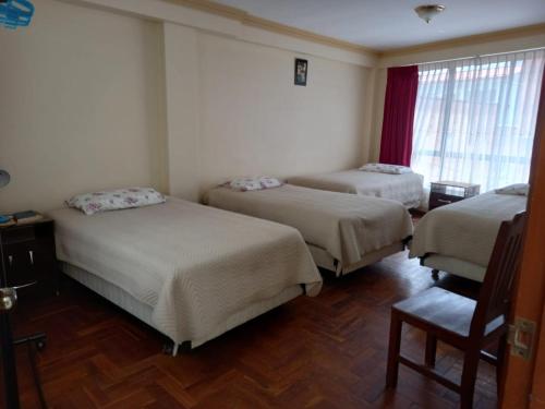 科帕卡巴纳Hostal Venegas的一间设有三张床和椅子的房间