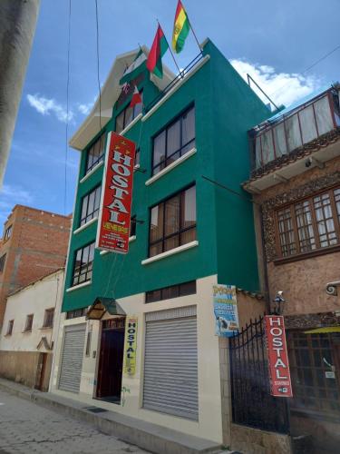 科帕卡巴纳Hostal Venegas的绿色建筑的侧面有标志