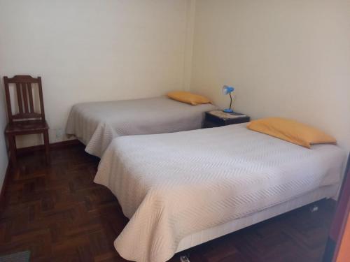 科帕卡巴纳Hostal Venegas的带桌子的客房内的两张单人床