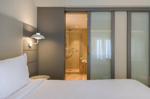 马德里马德里卡尔顿万豪AC酒店的卧室配有白色的床和淋浴