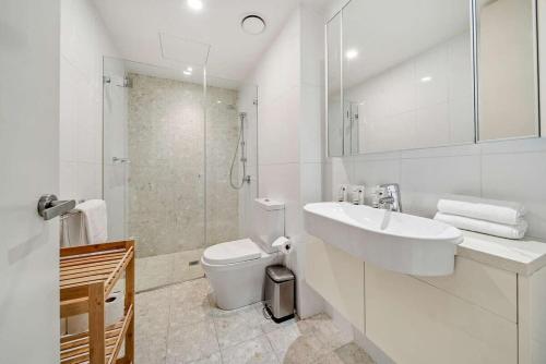 金斯顿Canberra Lakefront 2-Bed with Pool, Gym & Parking的白色的浴室设有水槽和卫生间。