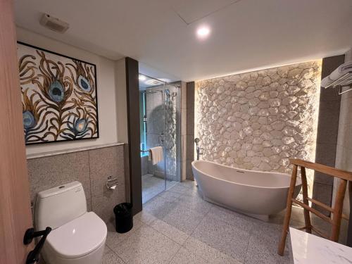 塞米亚克Luminor Hotel Legian Seminyak - Bali的带浴缸和卫生间的浴室。