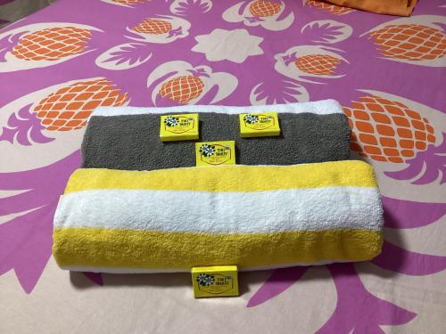 TaputapuapeaBungalow climatisé chez Kim的黄色和白色床上的毛巾