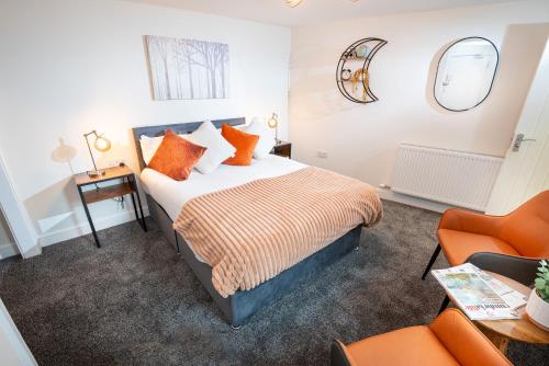 怀特黑Kings Arms Suites - Luxury Double - Waterfall Shower - Self Check In的一间卧室配有一张床和一张橙色椅子