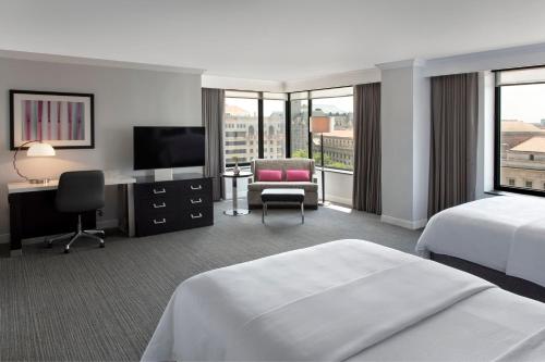 华盛顿华盛顿特区JW万豪酒店的酒店客房配有一张床、一张书桌和一台电视。