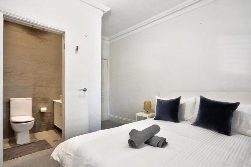 悉尼Good for Family 3 Bedroom House Darlinghurst with 2 E-Bikes Included的卧室配有带蓝色枕头的大型白色床
